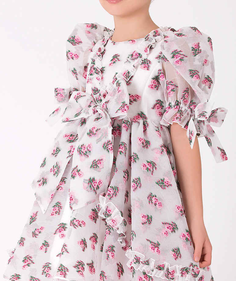 Vintage-inspired floral dress for girls – Elegant white dress with pink floral patterns, puff sleeves, and ruffle details.