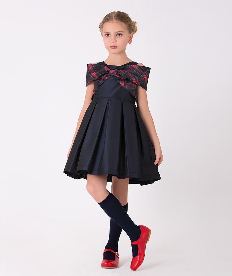 Girls' navy dress with large plaid bow – A charming plaid dress with a classic red and navy pattern, featuring a large navy bow at the neckline, perfect for holiday gatherings