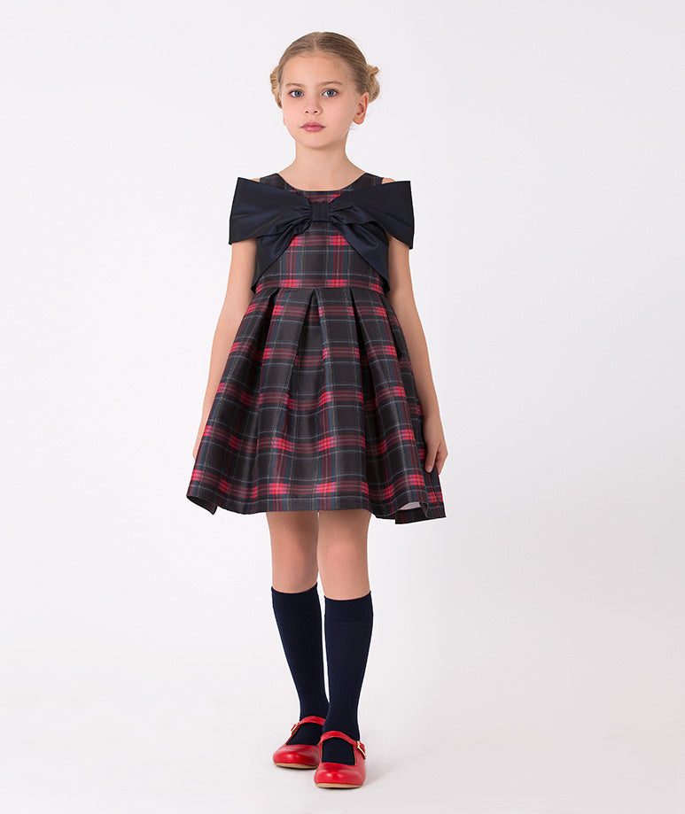Girls' plaid dress with large navy bow – A charming plaid dress with a classic red and navy pattern, featuring a large navy bow at the neckline, perfect for holiday gatherings