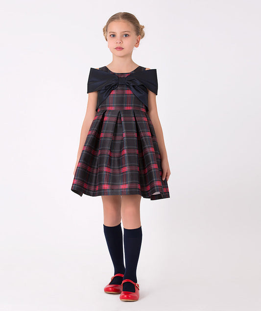 Girls' plaid dress with large navy bow – A charming plaid dress with a classic red and navy pattern, featuring a large navy bow at the neckline, perfect for holiday gatherings