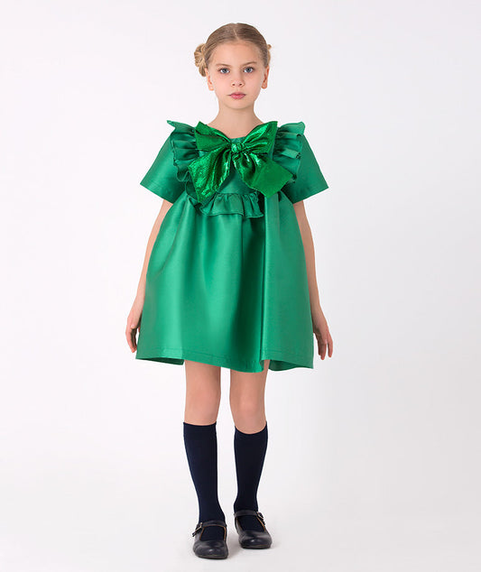 Girls' green dress with metallic bow and ruffle accents – A stylish green dress featuring a shimmering oversized bow and playful ruffles, perfect for festive occasions. 