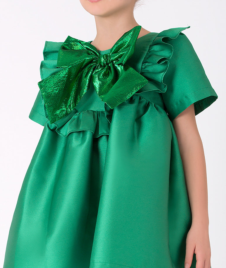 Elegant green girls' dress with statement bow. Fashion-forward dress with a bold metallic bow for a unique holiday look