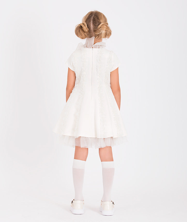 Fashion-forward white ruffle dress with a statement bow tie and layered skirt