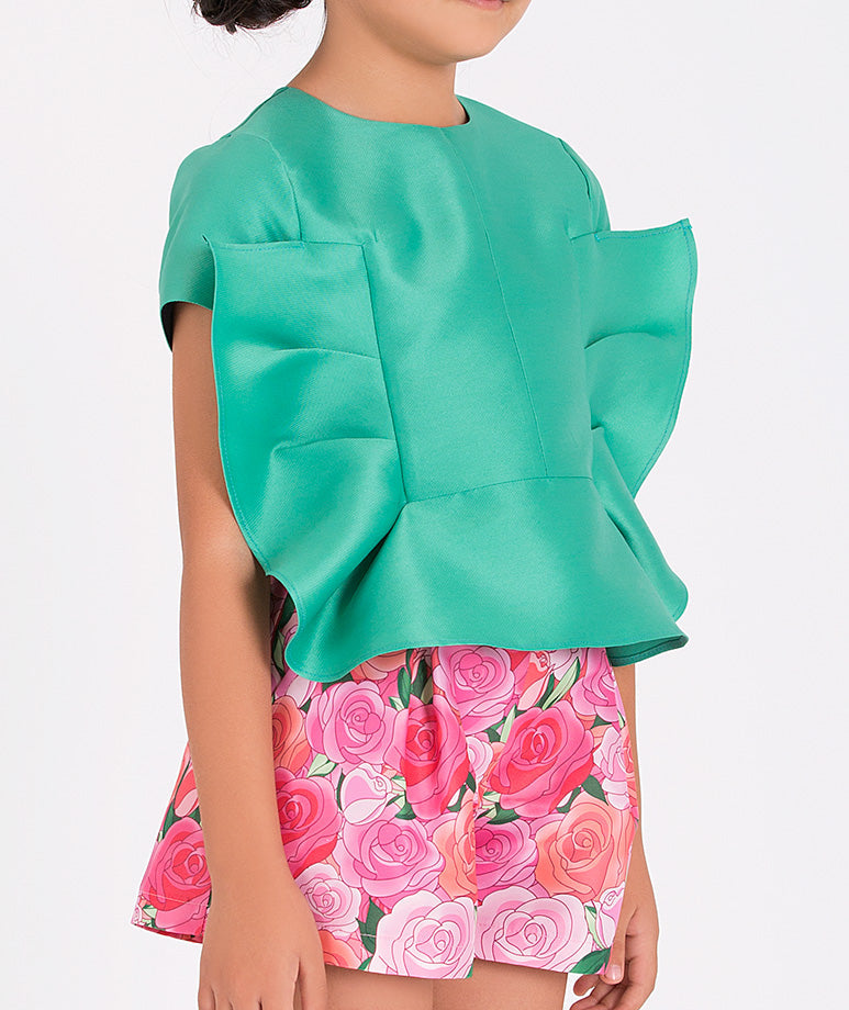 a mint blouse shaped like a bow and adorable pink rose-printed shorts