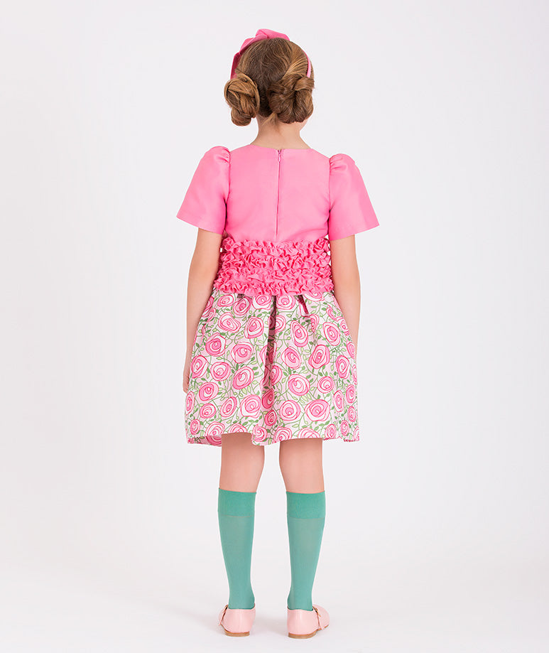 a pink blouse and a pink rose-printed skirt