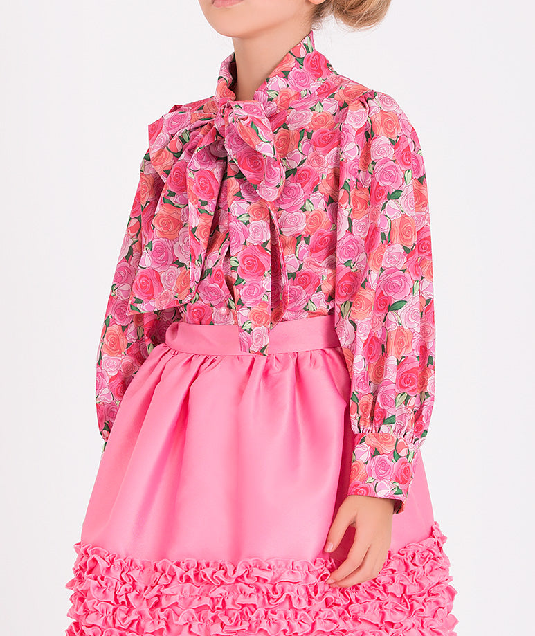 a rose-printed blouse and a chic pink skirt