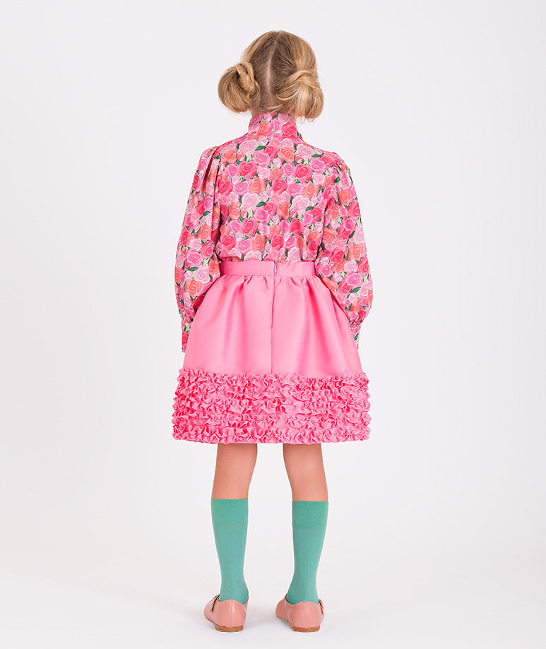 a rose-printed blouse and a pink skirt